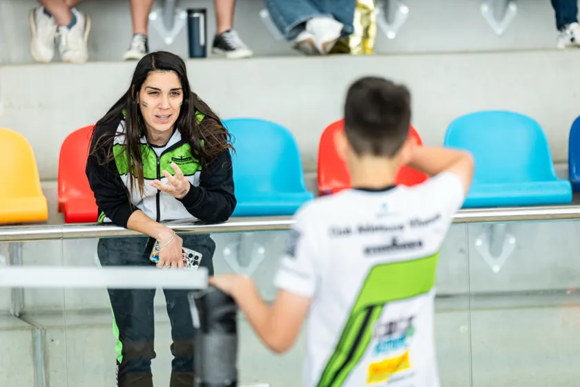 Entrenadora corregint la tècnica amb un atleta